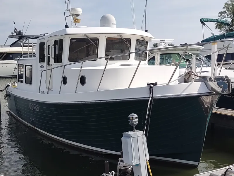 Slide: The Image of 2003 American Tug 34 docked, showcasing classic design and sturdy build. - 1