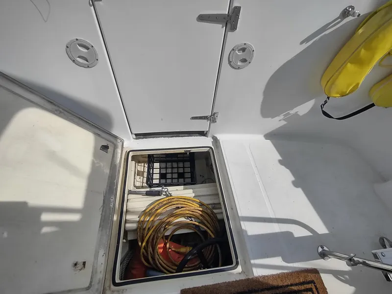 Slide: The Image of Storage compartment on a 2003 American Tug 34 boat, featuring coiled rope and safety equipment. - 11