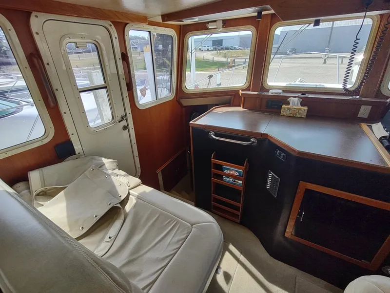 Slide: The Image of Interior of 2003 American Tug 34, featuring helm station and seating area. - 24