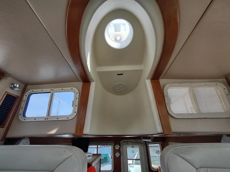 Slide: The Image of Interior view of 2003 American Tug 34, featuring windows and ceiling details. - 25