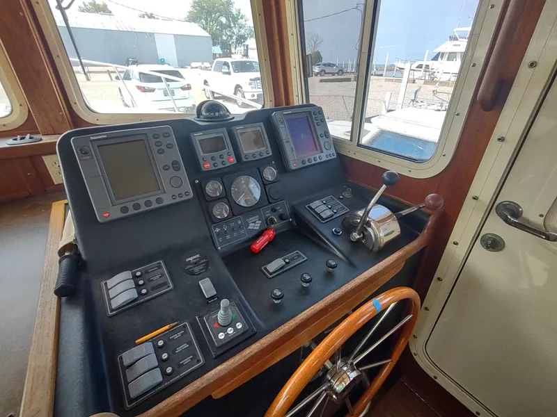 Slide: The Image of Pilothouse of 2003 American Tug 34 with navigation instruments and wooden steering wheel. - 26