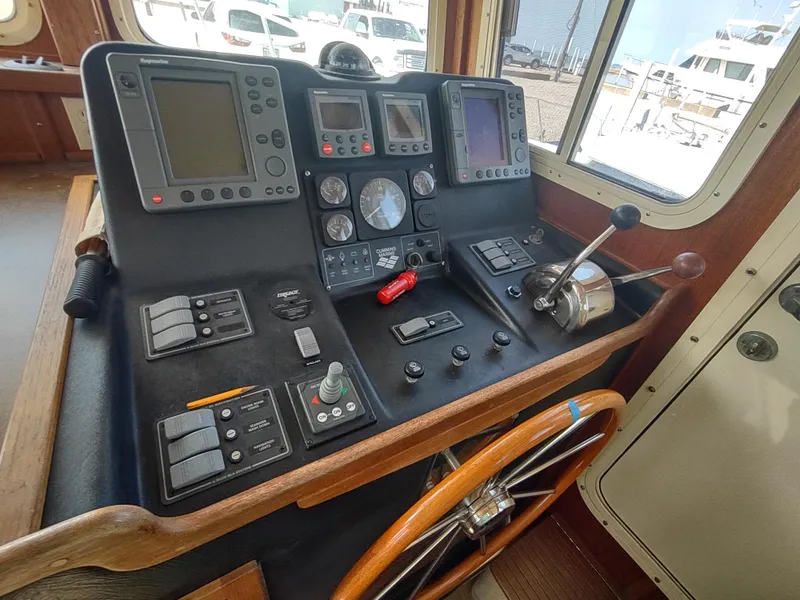 Slide: The Image of Control panel of a 2003 American Tug 34 with navigation instruments and steering wheel. - 31