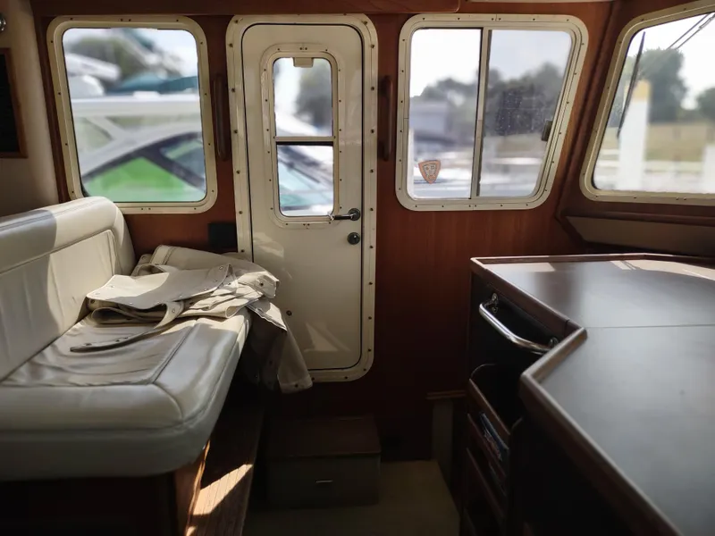 Slide: The Image of Interior of a 2003 American Tug 34, featuring seating and a door with windows. - 33