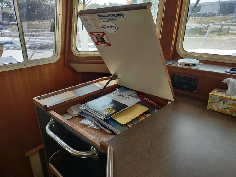Slide: The Image of Interior of a 2003 American Tug 34 with open storage compartment and documents. - 36