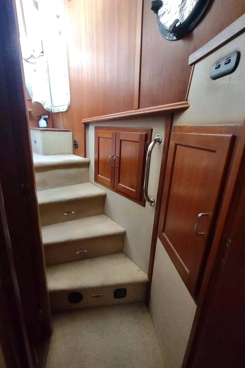 Slide: The Image of Interior stairs of 2003 American Tug 34 with wooden cabinets and carpeted steps. - 37