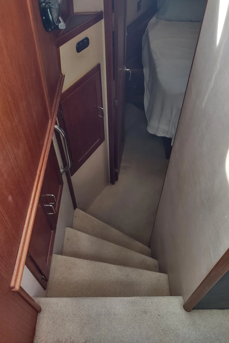 Slide: The Image of Stairway inside 2003 American Tug 34 boat, leading to a cozy cabin area. - 38