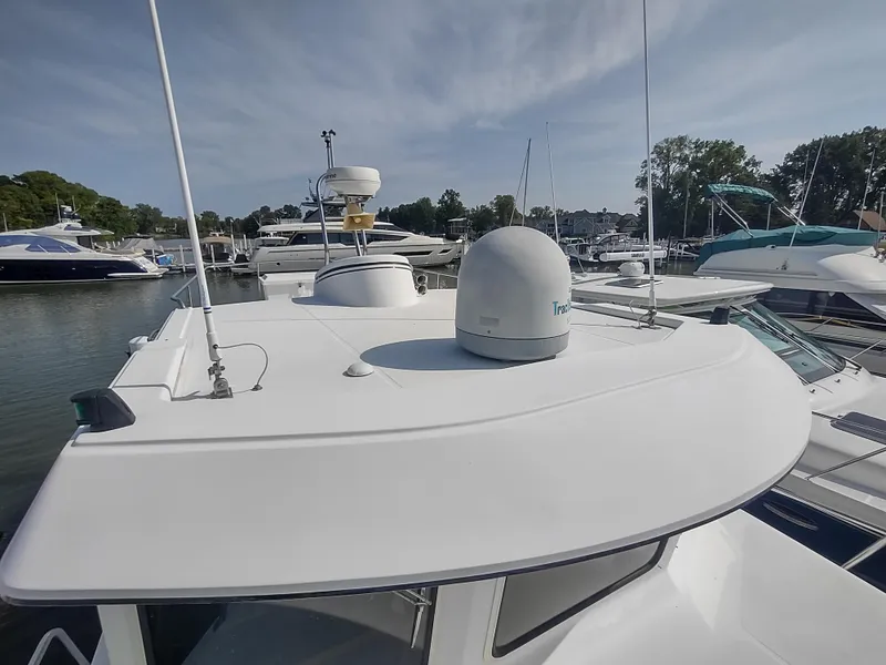 Slide: The Image of 2003 American Tug 34 boat docked in a marina, showcasing its roof and radar equipment. - 4