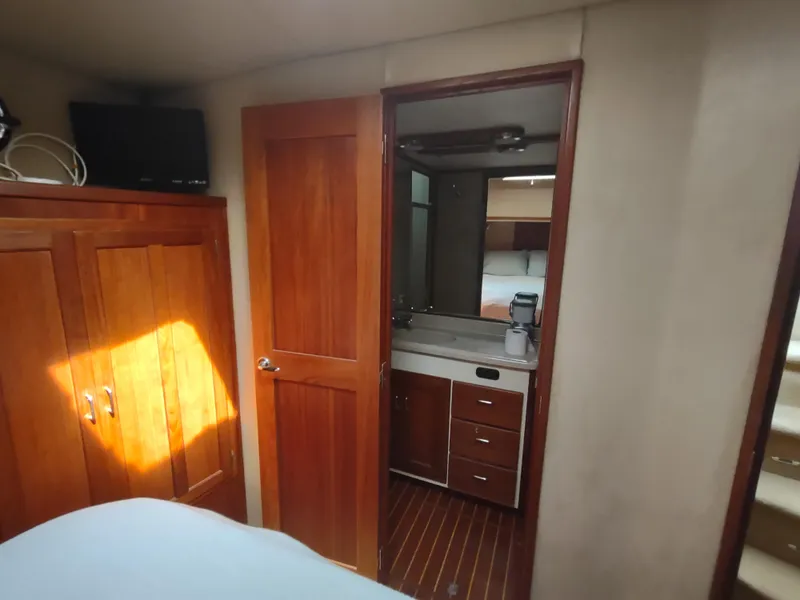 Slide: The Image of Interior of 2003 American Tug 34, featuring wooden cabinetry and a compact bathroom. - 41