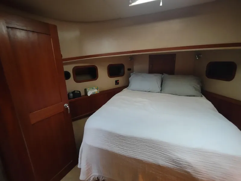 Slide: The Image of Cozy cabin interior of 2003 American Tug 34 with a comfortable bed and wooden accents. - 42