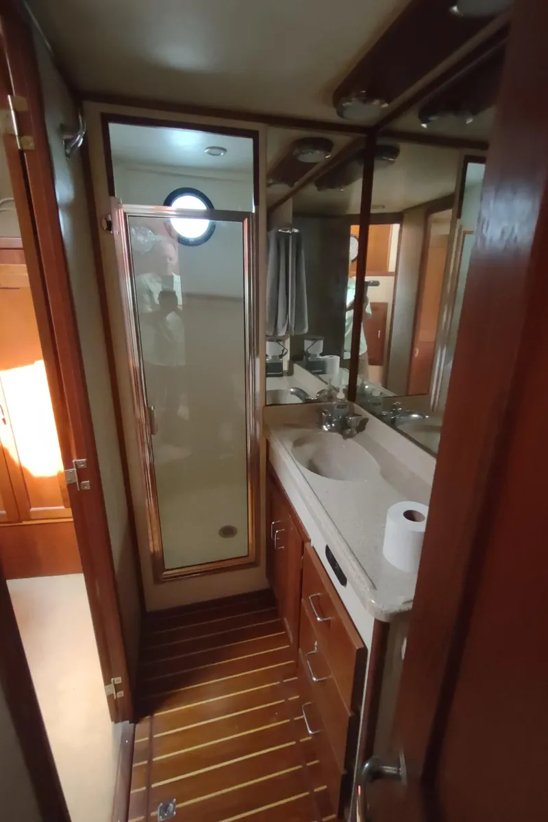 Slide: The Image of Bathroom interior of a 2003 American Tug 34, featuring wood accents and a mirrored cabinet. - 45