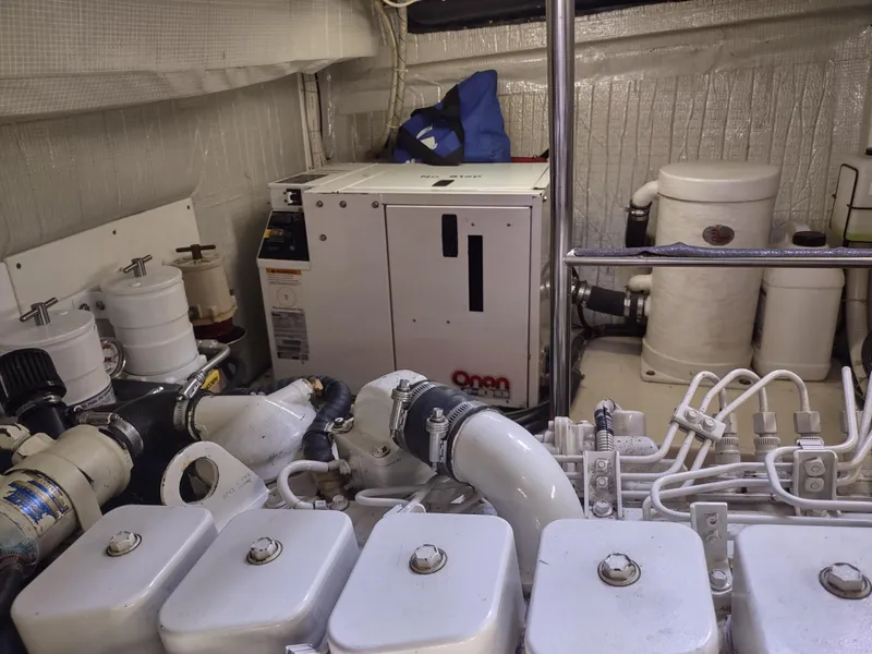 Slide: The Image of Engine room of a 2003 American Tug 34, featuring mechanical components and an Onan generator. - 47