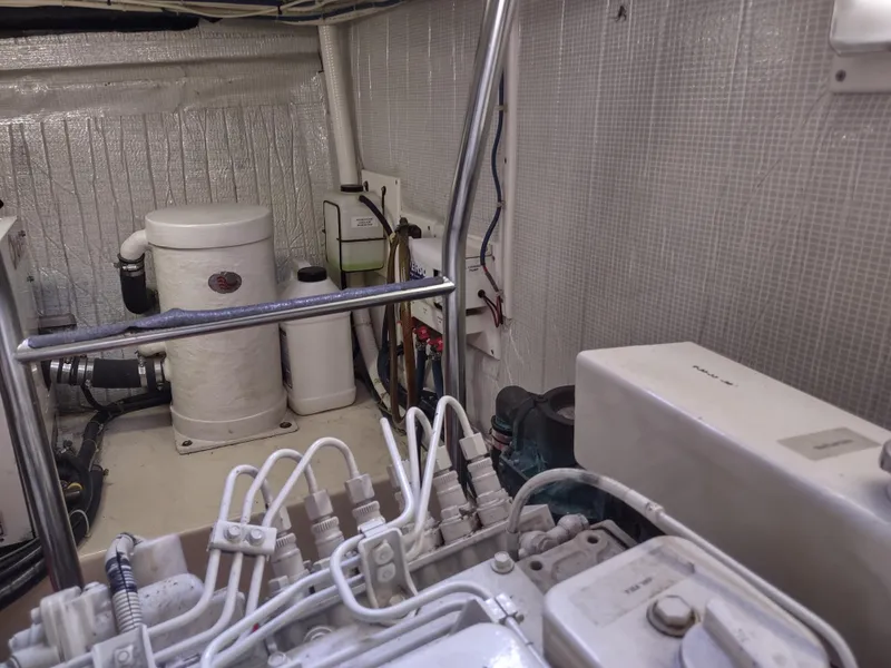 Slide: The Image of Engine room of a 2003 American Tug 34, featuring mechanical components and wiring. - 48