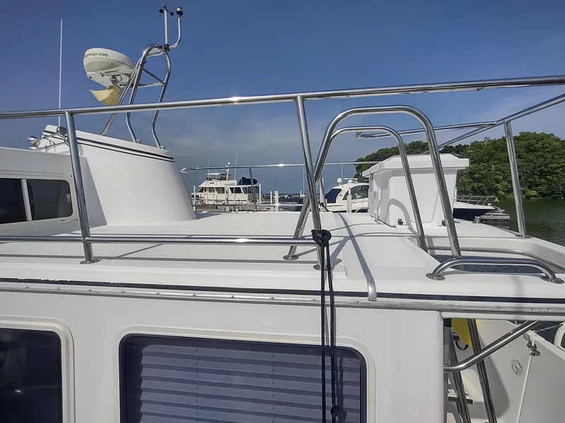 Slide: The Image of 2003 American Tug 34 boat deck with railing, docked near other boats. - 5