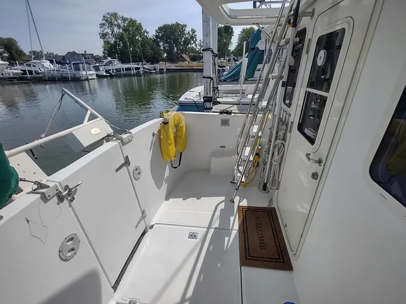 Slide: The Image of 2003 American Tug 34 boat deck with safety equipment, docked in a marina. - 8