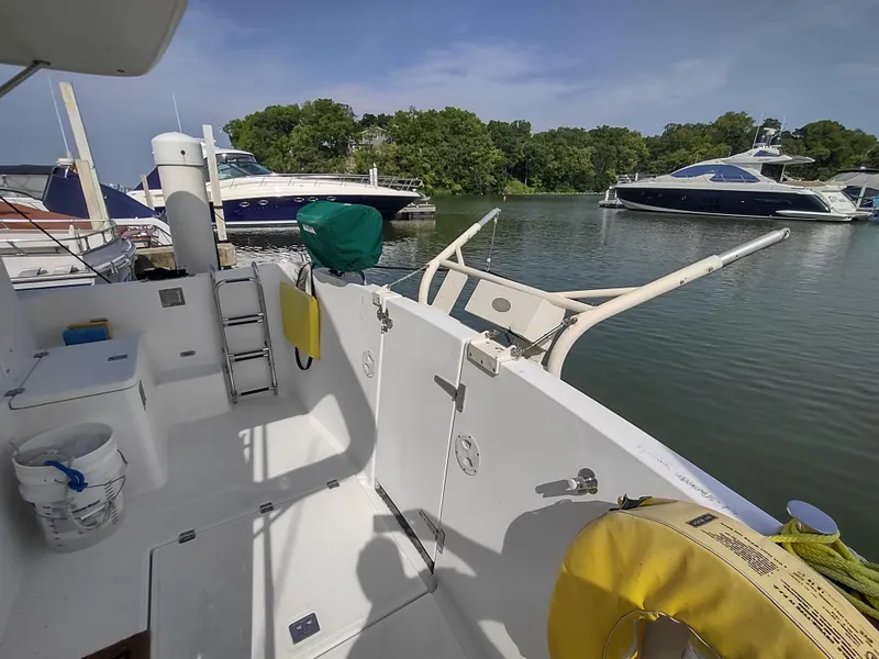 Slide: The Image of American Tug 34 (2003) boat deck with marina view, featuring safety equipment and moored yachts. - 9