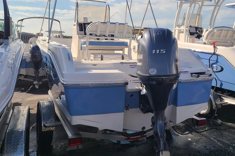 Slide: The Image of 2024 Robalo R180 Center Console boat with Yamaha 115 engine, docked outdoors. - 2