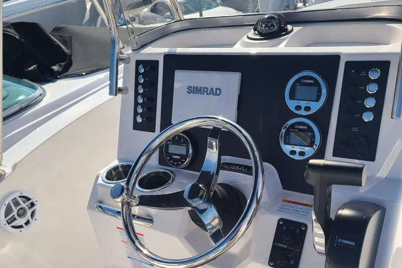 Slide: The Image of 2024 Robalo R180 Center Console boat dashboard with steering wheel and Simrad electronics. - 3