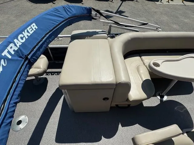 Slide: The Image of 2017 Sun Tracker Fishin' Barge 22 DLX interior with beige seating and table. - 11