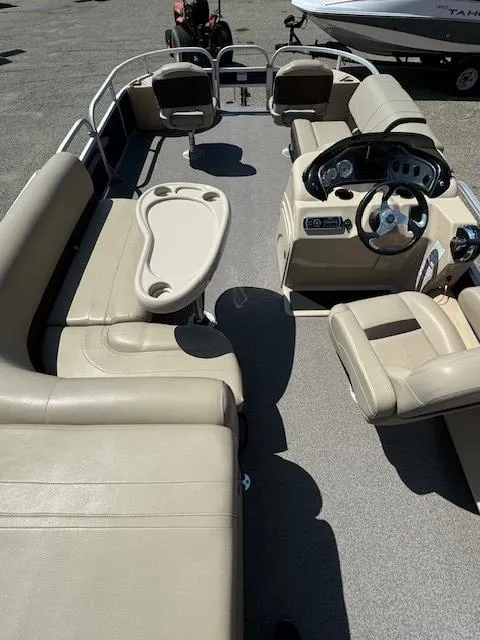 Slide: The Image of 2017 Sun Tracker Fishin' Barge 22 DLX interior with beige seating and steering console. - 13