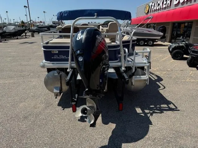Slide: The Image of 2017 Sun Tracker Fishin' Barge 22 DLX with outboard motor in a dealership lot. - 2