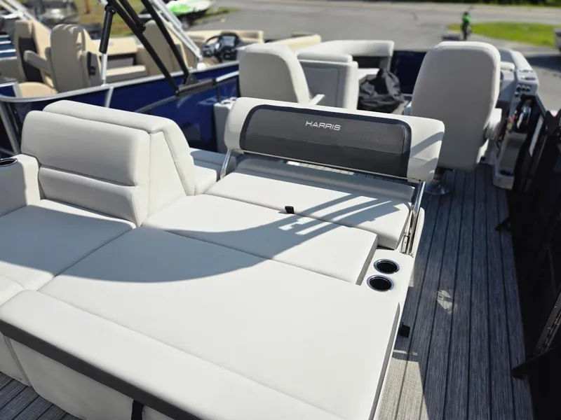 Slide: The Image of 2025 Harris Cruiser 230 boat interior with white seating and cup holders. - 2