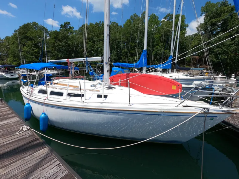 The Image of 1985 Catalina 30 sailboat docked at marina with blue fenders and red kayak. - 0