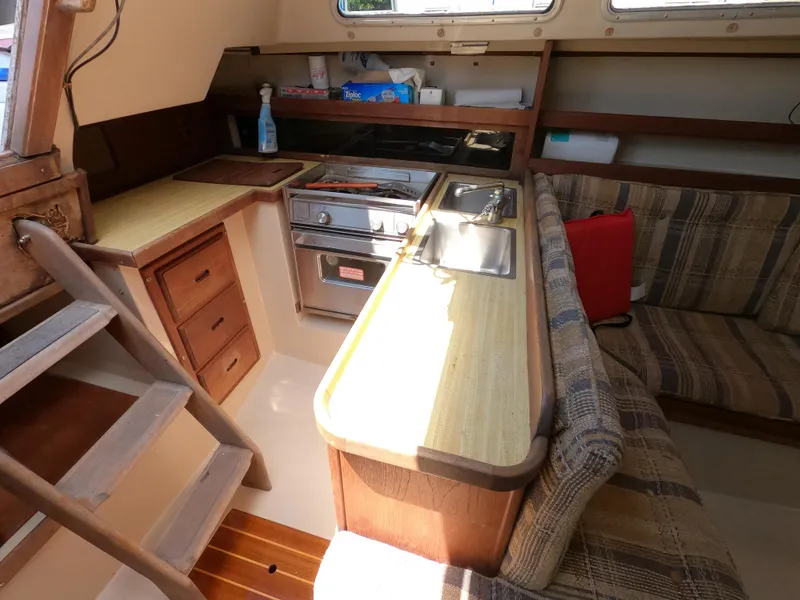 Slide: The Image of Interior of 1985 Catalina 30 sailboat with kitchen and seating area. - 13