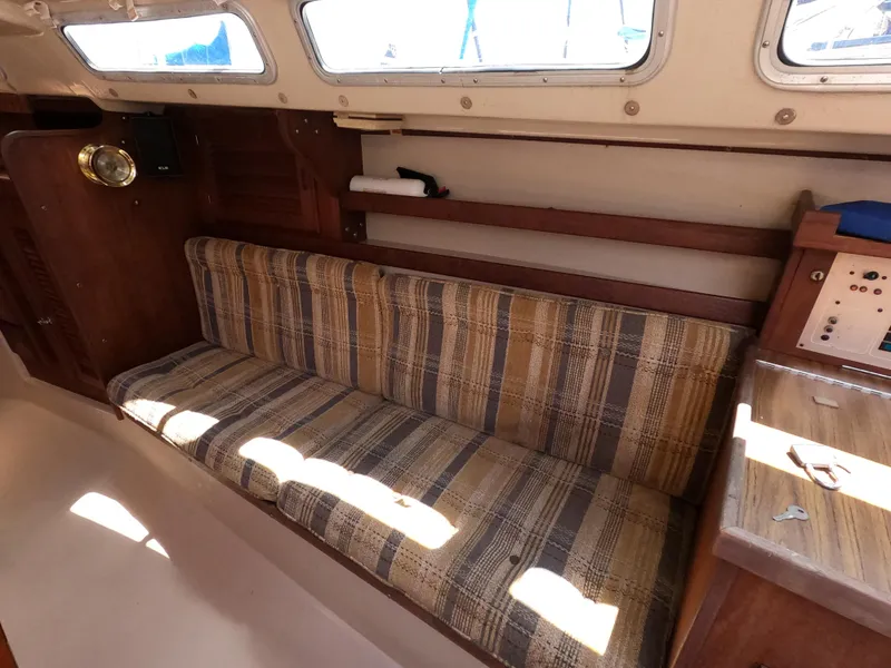 Slide: The Image of Interior of 1985 Catalina 30 sailboat with striped seating and wooden accents. - 15