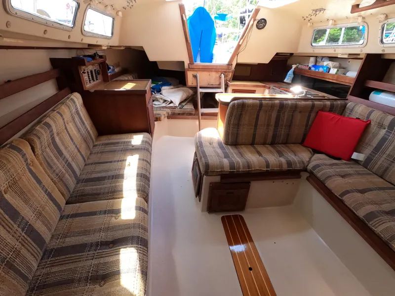 Slide: The Image of Interior of 1985 Catalina 30 sailboat with striped seating and wooden accents. - 19