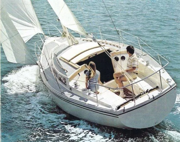 Slide: The Image of 1985 Catalina 30 sailboat with two people sailing on open water. - 22