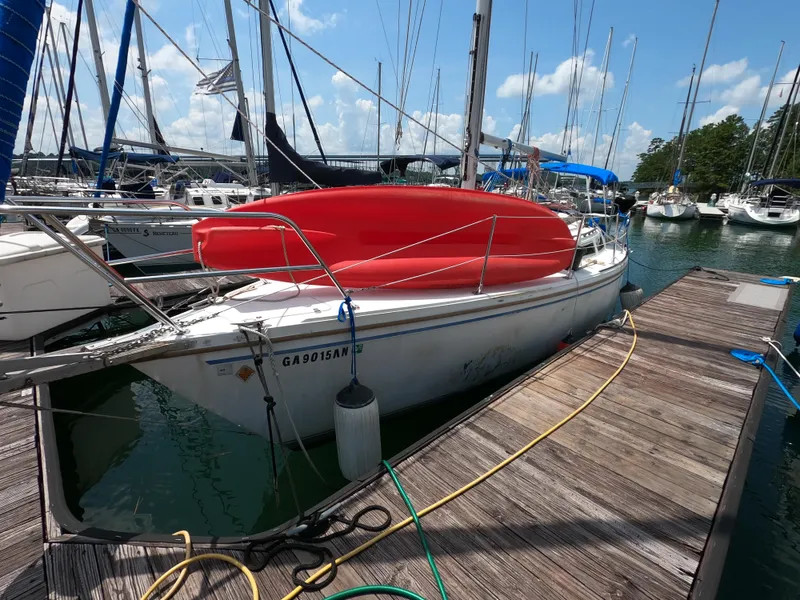 Slide: The Image of 1985 Catalina 30 sailboat docked at marina with red cover, surrounded by other boats. - 3