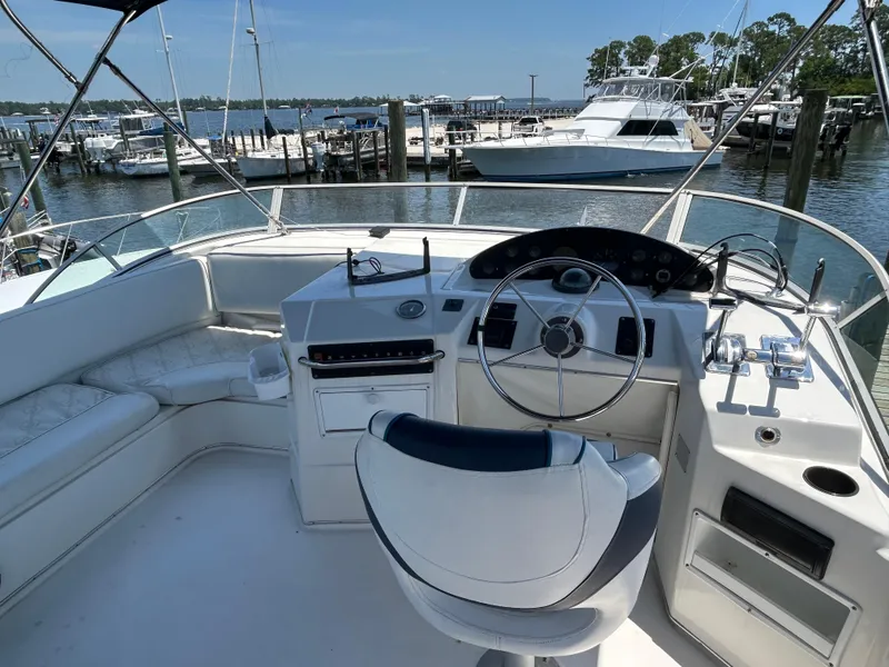Slide: The Image of 1997 Bayliner 3788 Command Bridge Motoryacht helm with marina view in the background. - 5