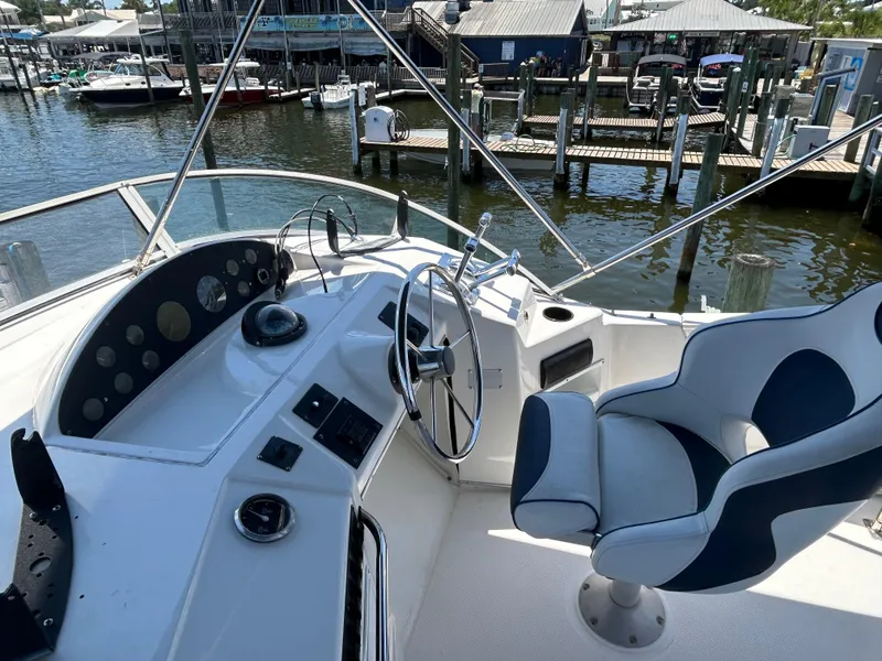 Slide: The Image of 1997 Bayliner 3788 Command Bridge Motoryacht helm with steering wheel and control panel. - 6