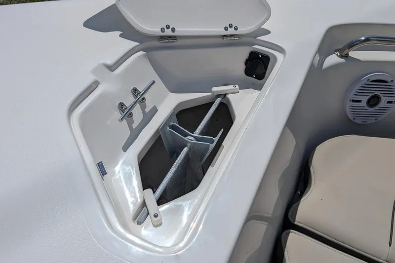 Slide: The Image of 2026 Key West 203 FS boat anchor storage compartment with open lid and seating area. - 19