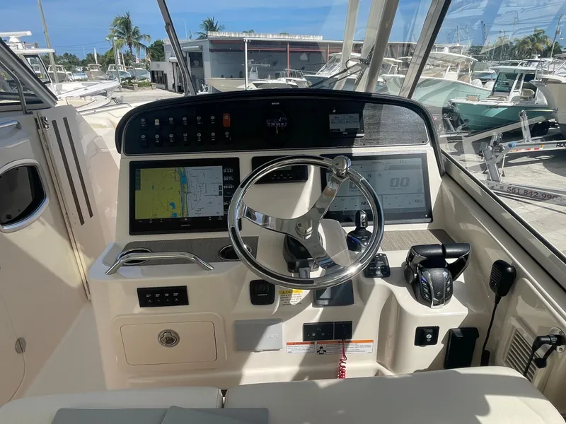 Slide: The Image of 2023 Grady-White Freedom 335 boat with enclosed cockpit, docked under clear blue sky. - 18