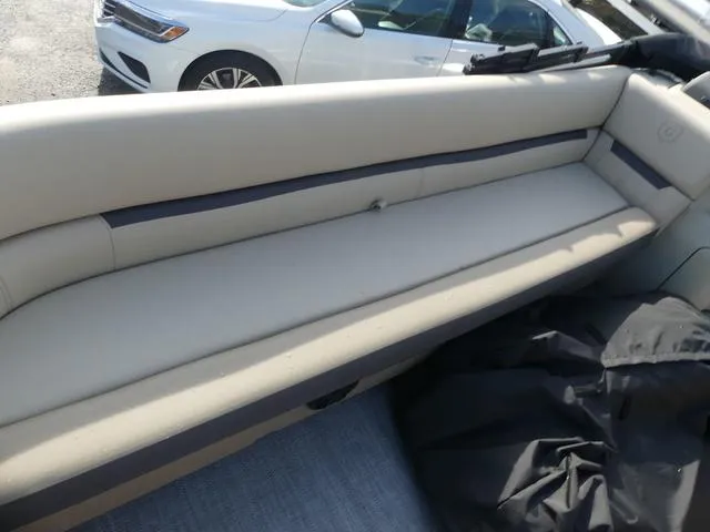 Slide: The Image of 2025 Godfrey Pontoons Sweetwater 2486 C interior with beige seating and black cover. - 10