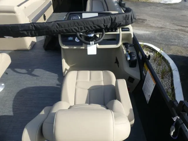 Slide: The Image of 2025 Godfrey Pontoons Sweetwater 2486 C interior with beige seating at marina. - 7