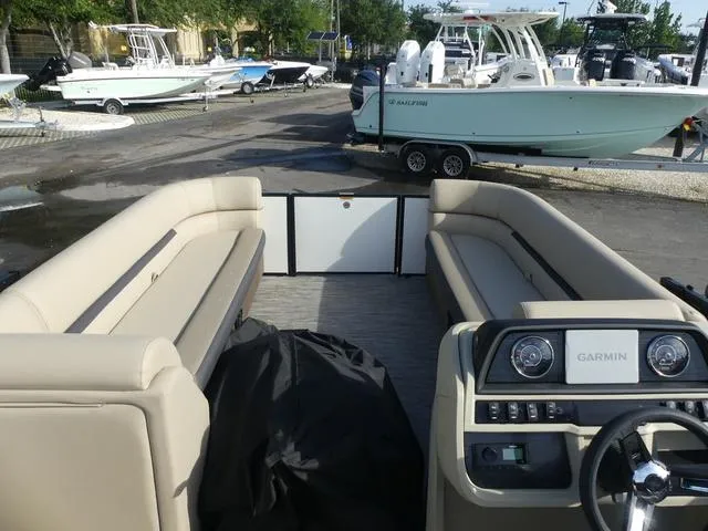 Slide: The Image of 2025 Godfrey Pontoons Sweetwater 2286 SB interior with Garmin dashboard, docked among other boats. - 7