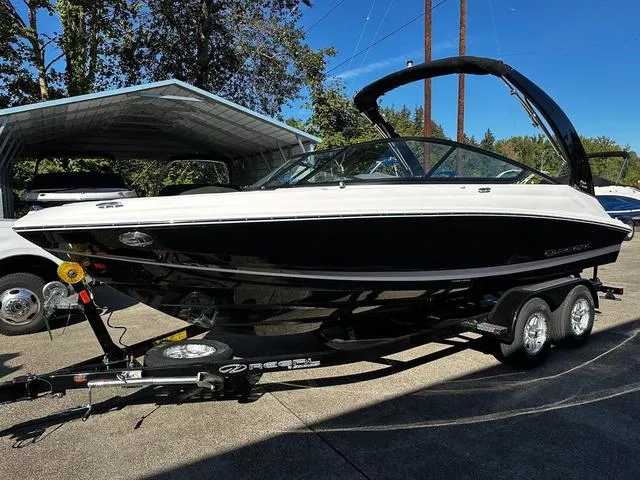Slide: The Image of 2025 Regal 2000 ES boat on trailer, parked outdoors under clear sky. - 11