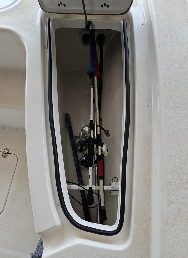 Slide: The Image of 2020 Sea Pro 248 Bay boat storage compartment with fishing rods. - 33