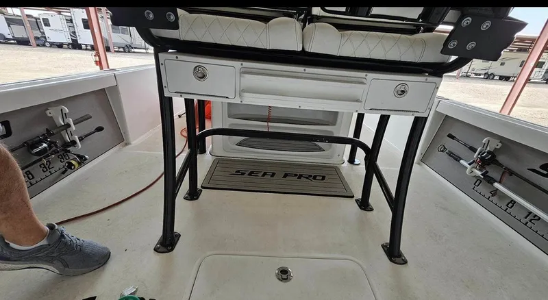 Slide: The Image of 2020 Sea Pro 248 Bay boat interior with fishing rod holders and storage compartments. - 35