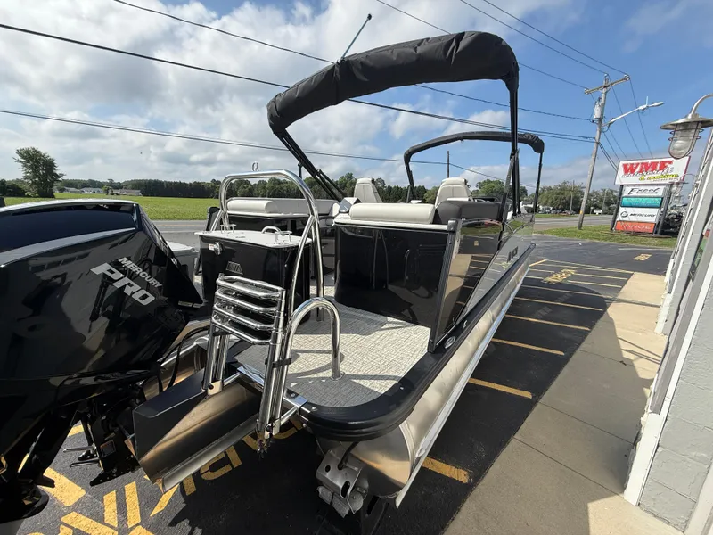 Slide: The Image of 2025 Avalon 2385 Catalina Quad Lounger Tri Toon boat with high-performance features, parked outdoors. - 12