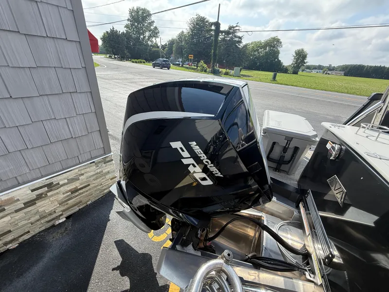 Slide: The Image of 2025 Avalon 2385 Catalina Quad Lounger with Mercury Pro outboard motor in a sunny outdoor setting. - 14