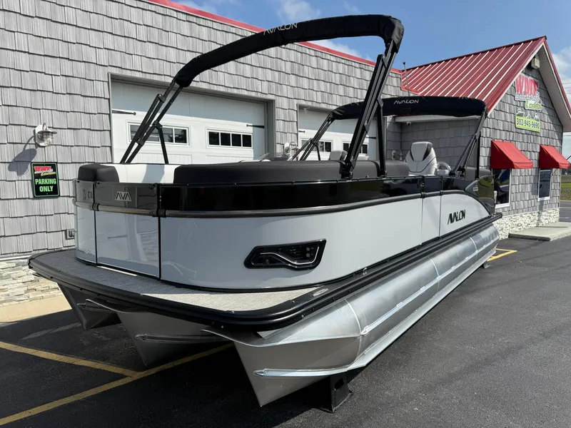 Slide: The Image of 2025 Avalon 2385 Catalina Quad Lounger Tri Toon, parked outside a building on a sunny day. - 3