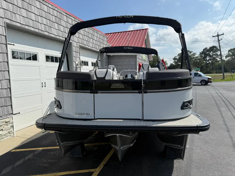 Slide: The Image of 2025 Avalon 2385 Catalina Quad Lounger Tri Toon boat, parked outside a building. - 5
