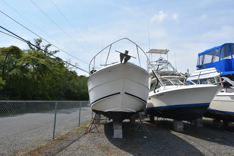 Slide: The Image of 2000 Monterey 302 Cruiser boat on dry dock, surrounded by other vessels. - 2