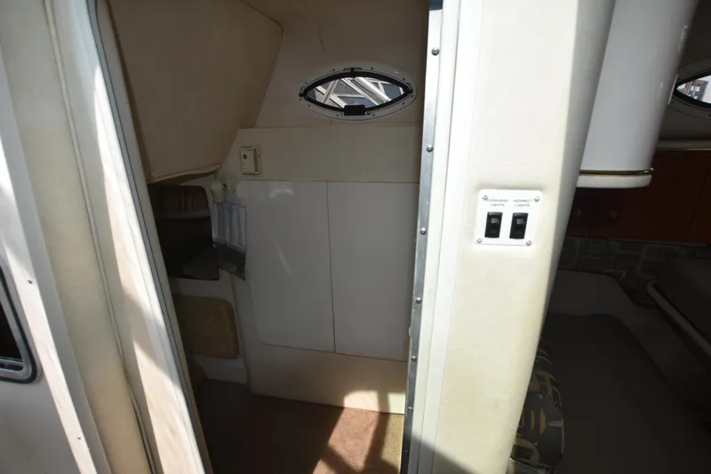 Slide: The Image of Interior cabin of 2000 Monterey 302 Cruiser boat, featuring compact design and porthole window. - 20