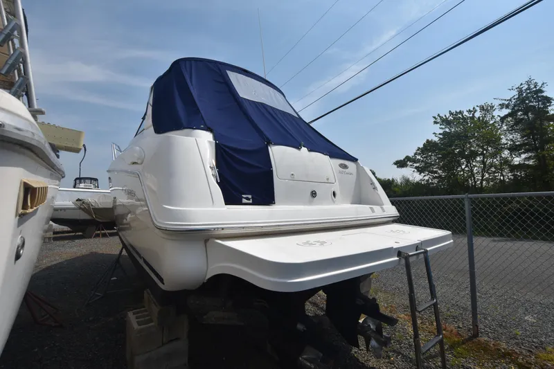 Slide: The Image of 2000 Monterey 302 Cruiser boat with blue cover, parked on gravel. - 5