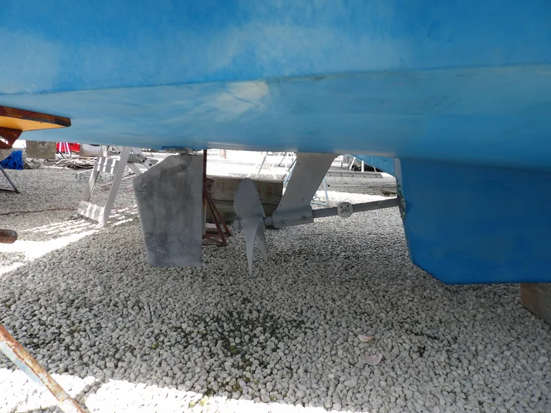 Slide: The Image of 1999 Mainship 350 Trawler underside with propeller and rudder on gravel surface. - 10
