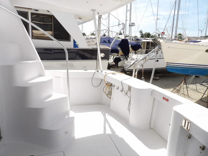 Slide: The Image of 1999 Mainship 350 Trawler deck with stairs, docked among other boats. - 13